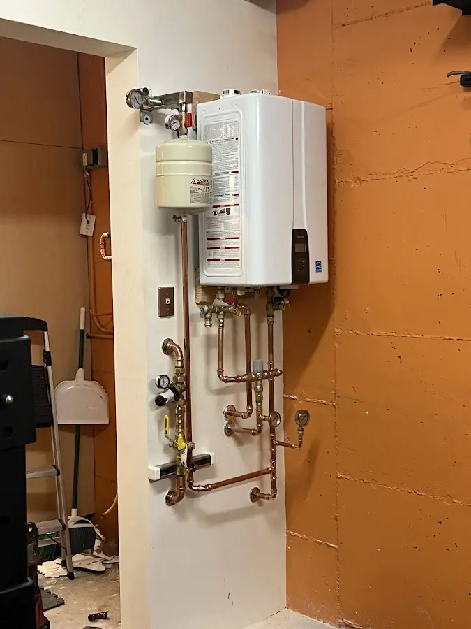 Plumbing technician inspecting water heater connections in East Honolulu